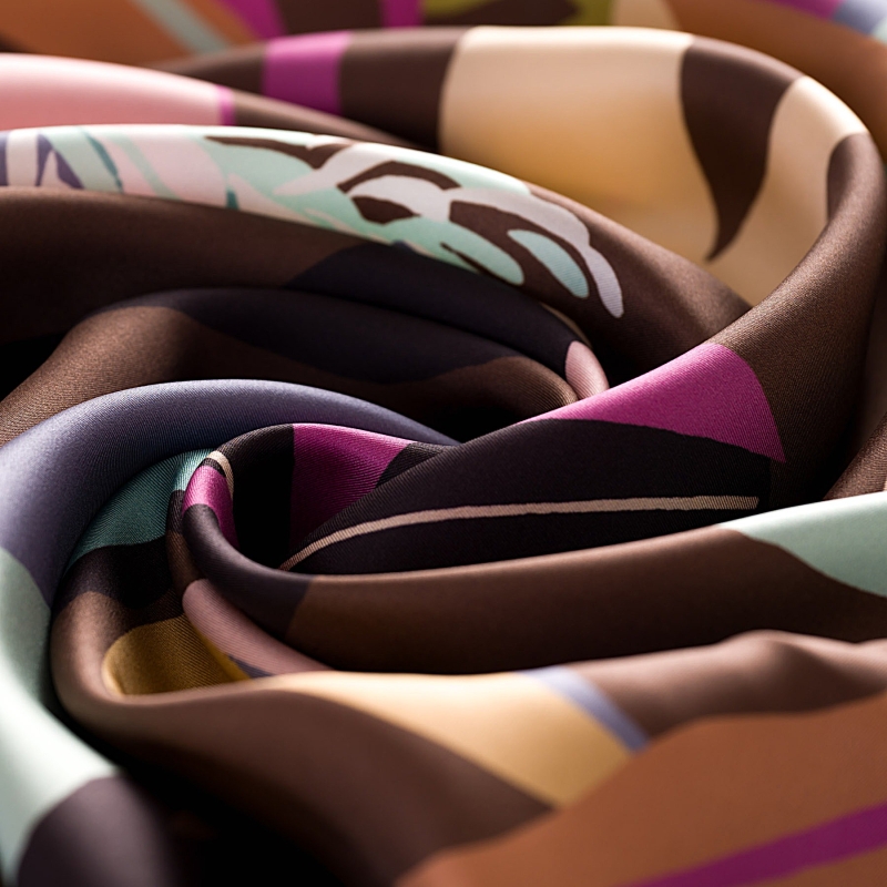 Esarfa de matase cu imprimeu floral abstract, culori pastelate pe fond maro.